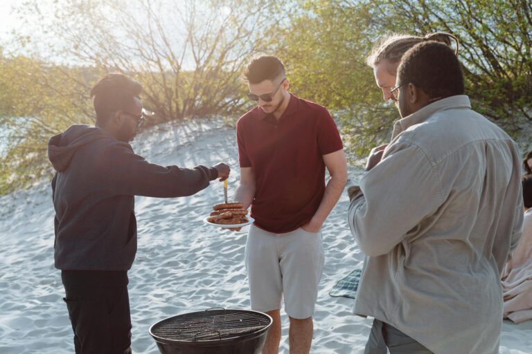 A Man Putting Grilled Sausages on a White Plate